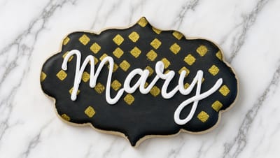 Black and gold name plaque cookie with hand-piped white script — custom decorated cookies by Dreams of Buttercream