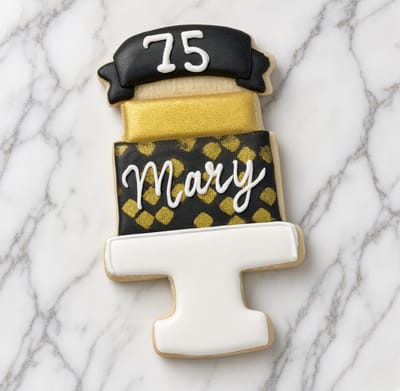 Black and gold tiered cake cookie topped with a seventy-five — custom decorated cookies by Dreams of Buttercream