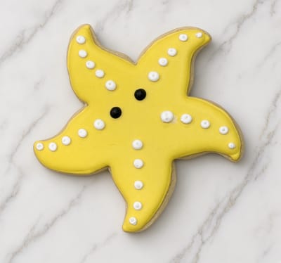 Yellow starfish cookie with white piped dots — custom decorated cookies by Dreams of Buttercream